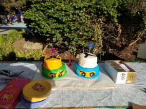 Two ninjago cakes, one on left is green and on right is blue